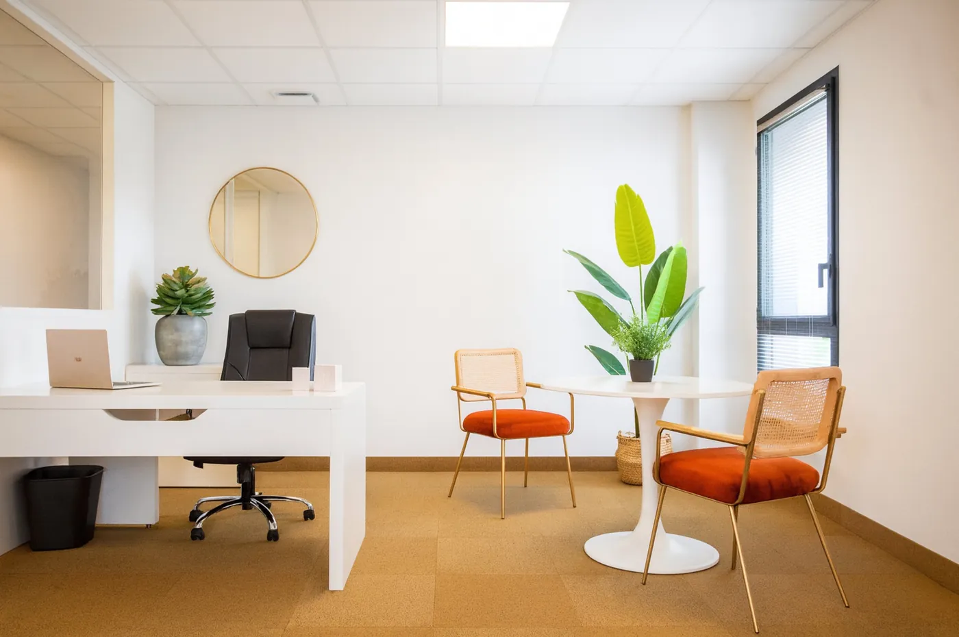 Executive office with white desk and orange velvet chairs at the sister Garosud centre